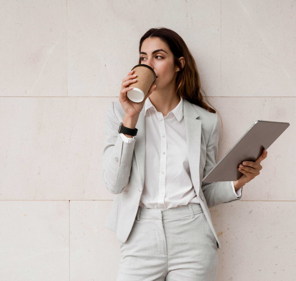 elegante-geschaeftsfrau-die-kaffee-beim-halten-der-tablette-trinkt-1 Kerkhoff Design - Webdesign
